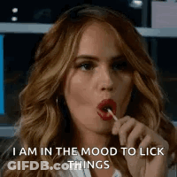 A Woman Is Licking A Lollipop In Her Mouth While Saying `` I Am In The Mood To Lick Things '' . GIF