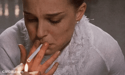 A Woman Is Lighting A Cigarette With A Lighter . GIF
