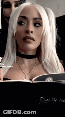 A Woman Is Looking At A Book Titled Death Note GIF