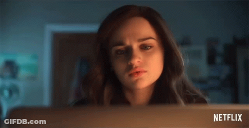 A Woman Is Looking At A Laptop Screen With A Netflix Logo In The Corner . GIF