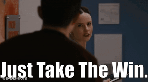A Woman Is Looking At A Man With The Words Just Take The Win Behind Her GIF