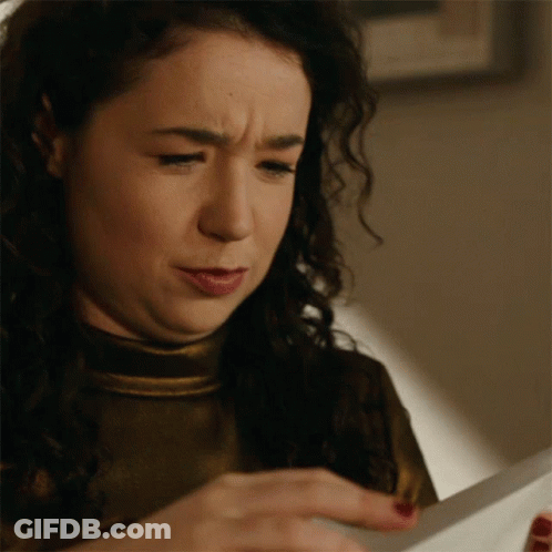 A Woman Is Looking At A Piece Of Paper And Making A Funny Face GIF