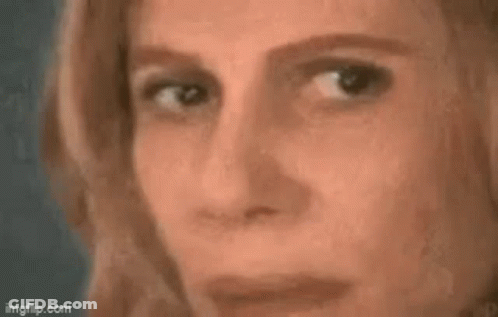 A Woman Is Looking At A Triangle On A Blackboard With A Math Problem . GIF