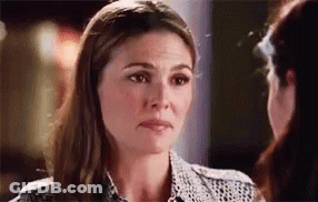 A Woman Is Looking At Another Woman 'S Face And Making A Funny Face . GIF