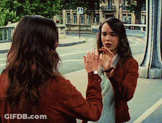 A Woman Is Looking At Herself In A Mirror GIF
