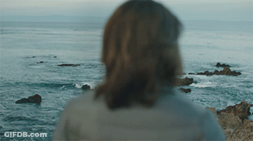 A Woman Is Looking Out Over The Ocean GIF