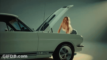 A Woman Is Looking Under The Hood Of A Gt 350 GIF