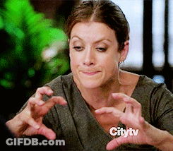 A Woman Is Making A Face With Her Hands In Front Of A Citytv Sign GIF