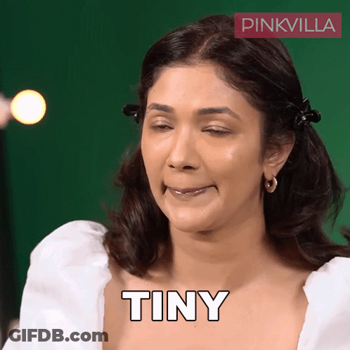 A Woman Is Making A Funny Face And The Word Tiny Is On Her Chest GIF