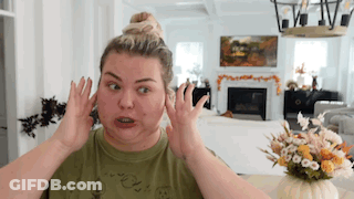 A Woman Is Making A Funny Face In A Living Room While Covering Her Ears With Her Hands . GIF