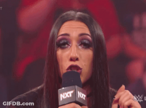A Woman Is Making A Funny Face In Front Of A Crowd Of People . GIF