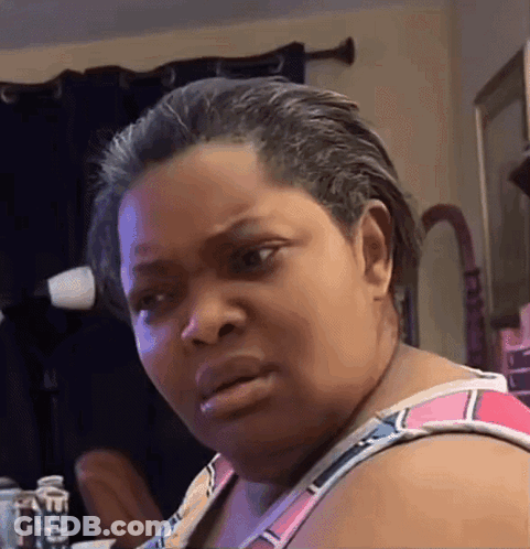 A Woman Is Making A Funny Face In Front Of A Mirror . GIF