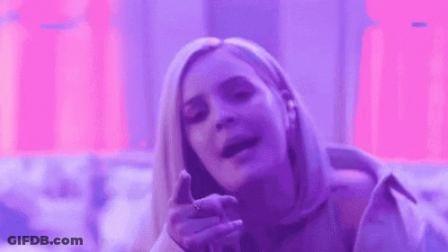 A Woman Is Making A Funny Face In Front Of A Purple Background . GIF