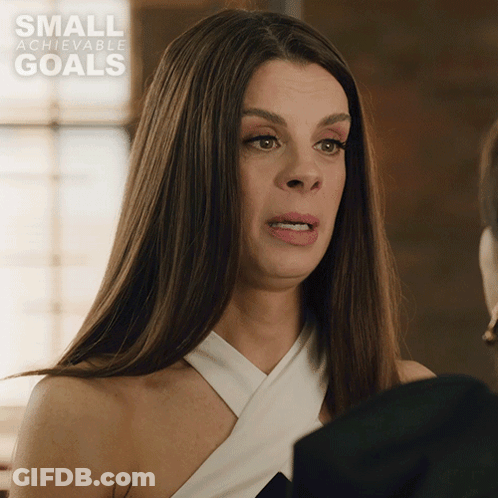 A Woman Is Making A Funny Face In Front Of A Small Achievable Goals Ad GIF