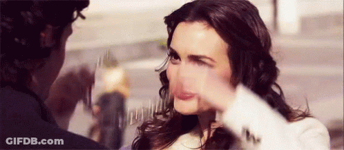 A Woman Is Making A Funny Face While A Man Holds Her Face . GIF
