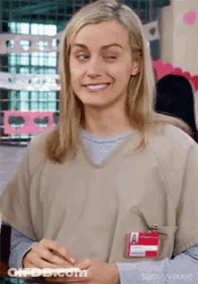 A Woman Is Making A Funny Face While Holding A Notebook And Smiling . GIF