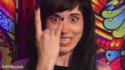 A Woman Is Making A Funny Face While Holding Her Finger To Her Nose . GIF