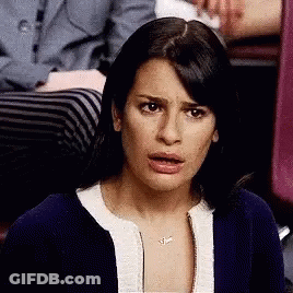 A Woman Is Making A Funny Face While Sitting In A Chair . GIF