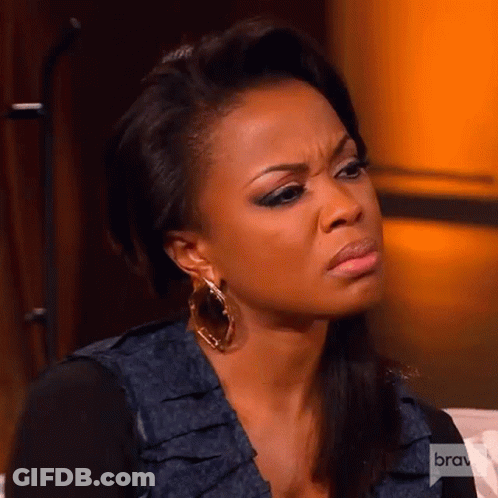 A Woman Is Making A Funny Face While Sitting On A Couch . GIF