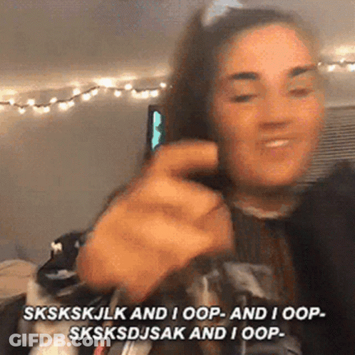 A Woman Is Making A Funny Face While Talking On A Cell Phone In A Room . GIF