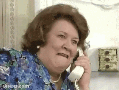 A Woman Is Making A Funny Face While Talking On A Phone . GIF
