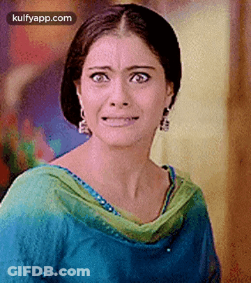A Woman Is Making A Funny Face While Wearing A Blue And Green Dress . GIF