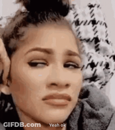 A Woman Is Making A Funny Face With Her Eyes Closed And A Bun In Her Hair . GIF