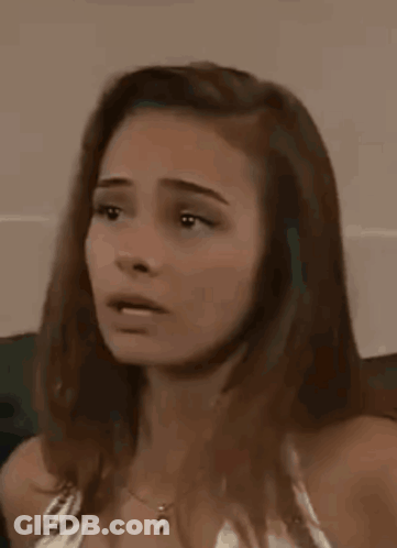 A Woman Is Making A Funny Face With Her Eyes Closed And Her Mouth Open . GIF