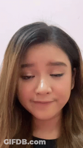 A Woman Is Making A Funny Face With Her Eyes Closed . GIF