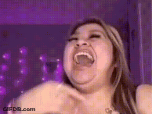 A Woman Is Making A Funny Face With Her Mouth Open And Purple Lights In The Background . GIF