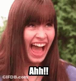 A Woman Is Making A Funny Face With Her Mouth Open And The Words `` Ahh '' Written On Her Face . GIF