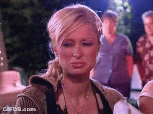 A Woman Is Making A Funny Face With Her Mouth Open While Standing In Front Of A Group Of People . GIF