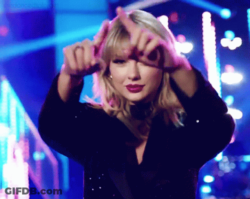 A Woman Is Making A Heart Shape With Her Hands In Front Of Her Face GIF
