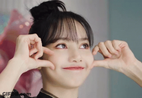 A Woman Is Making A Heart Shape With Her Hands GIF