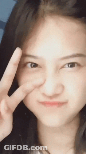 A Woman Is Making A Peace Sign With Her Hand GIF