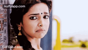 A Woman Is Making A Sad Face While Standing In Front Of A Wall . GIF