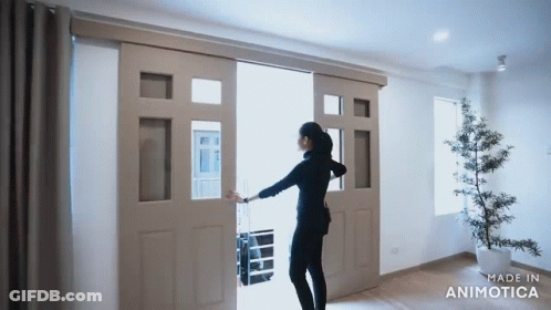 A Woman Is Opening A Sliding Glass Door Made By Animatica GIF