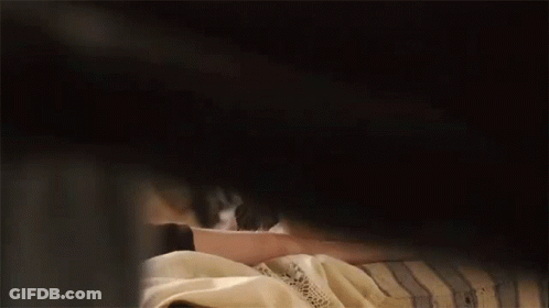 A Woman Is Peeking Out From Behind A Man 'S Shoulder . GIF