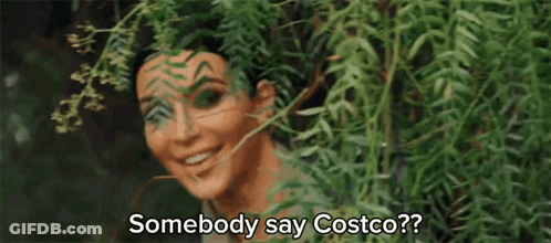 A Woman Is Peeking Out From Behind A Tree And Smiling While Saying Somebody Say Costco ? GIF