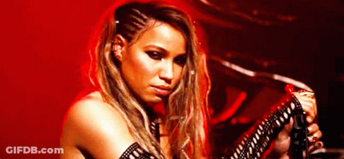 A Woman Is Playing A Guitar In Front Of A Red Background GIF