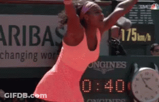 A Woman Is Playing Tennis In Front Of A Sign That Says ' Aribas Changing Work ' GIF