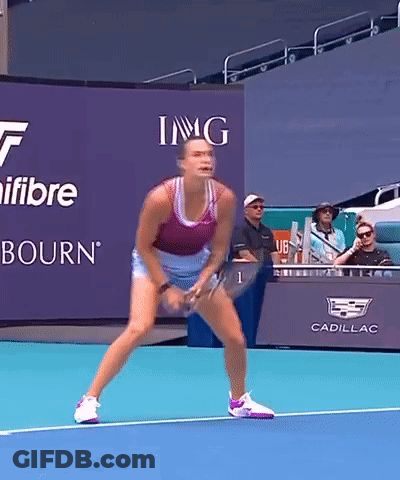 A Woman Is Playing Tennis In Front Of A Sign That Says Img On It GIF