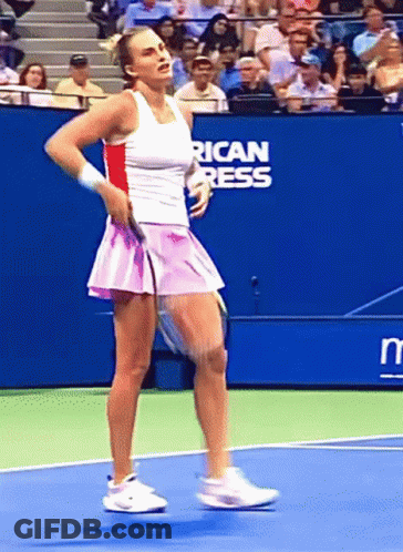 A Woman Is Playing Tennis On A Court With An American Press Sign Behind Her GIF
