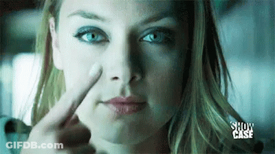 A Woman Is Pointing Her Finger At Her Nose . GIF