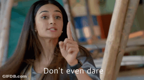 A Woman Is Pointing Up With The Words " Don 'T Even Dare " Written Below Her GIF