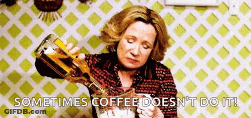 A Woman Is Pouring A Bottle Of Alcohol Into A Glass . GIF