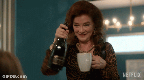 A Woman Is Pouring A Bottle Of Champagne Into A Cup With Netflix Written On The Bottom GIF
