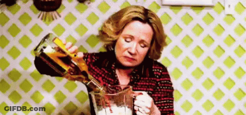 A Woman Is Pouring Alcohol Into A Pitcher . GIF