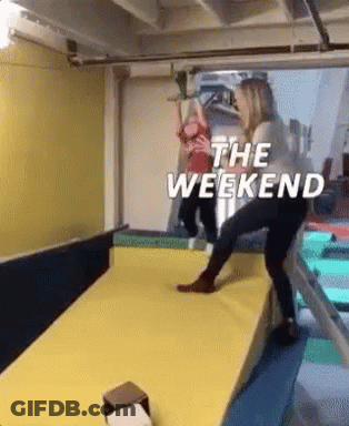 A Woman Is Pushing A Child On A Slide With The Words `` The Weekend '' Written On It . GIF