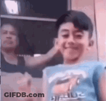 A Woman Is Putting A Hand On A Young Boy 'S Ear . GIF